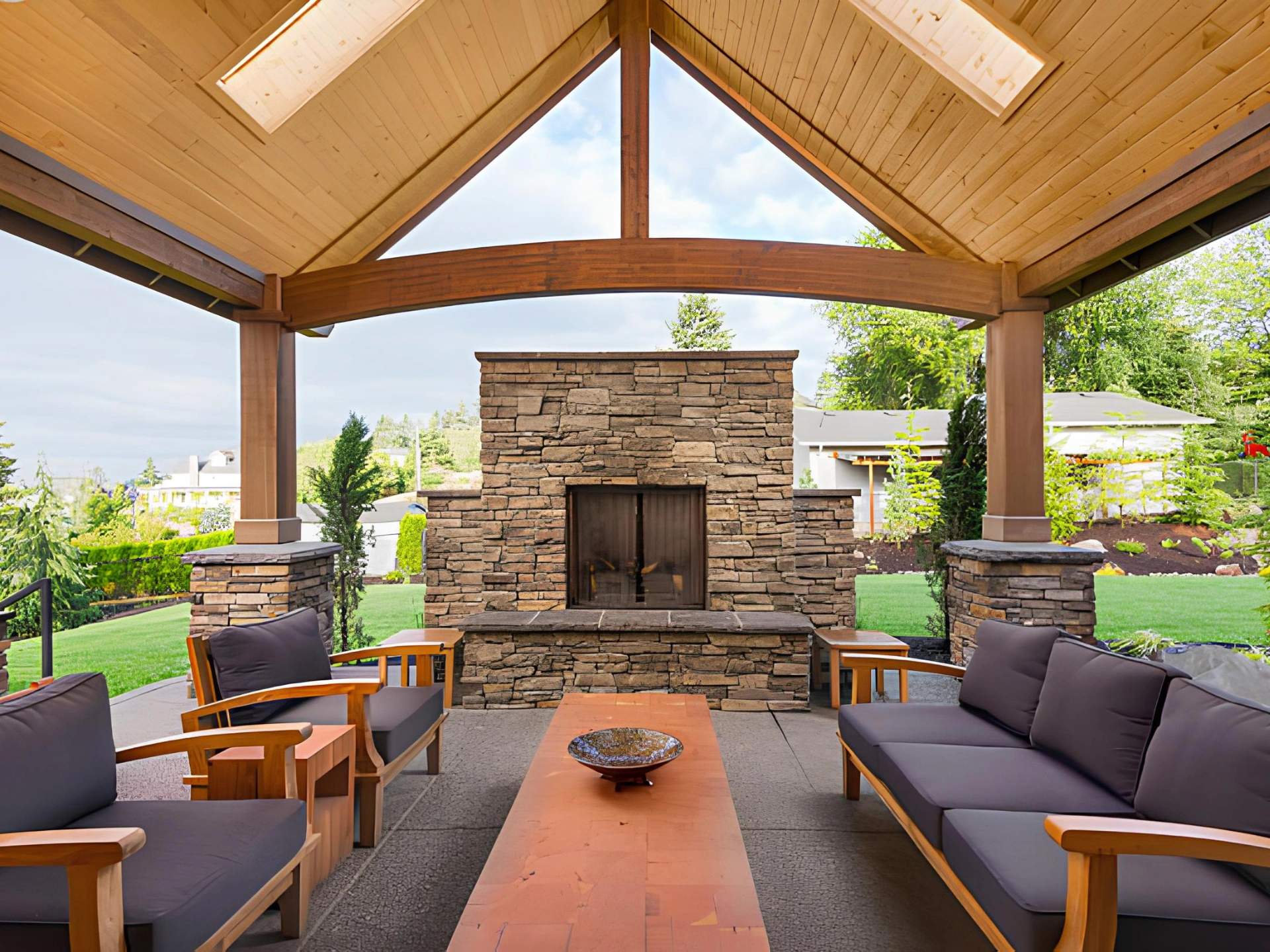 covered-patio-with-natural-stone-fireplace-and-outdoor-living-furniture-with-wooden-ceiling-in-needham-ma