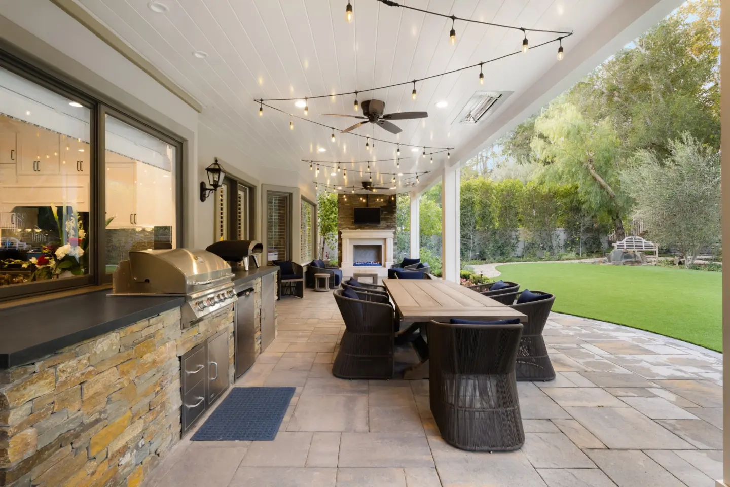 interior-shot-of-an-outdoor-kitchen-with-fireplace-and-a-clean-lawn-in-needham-ma