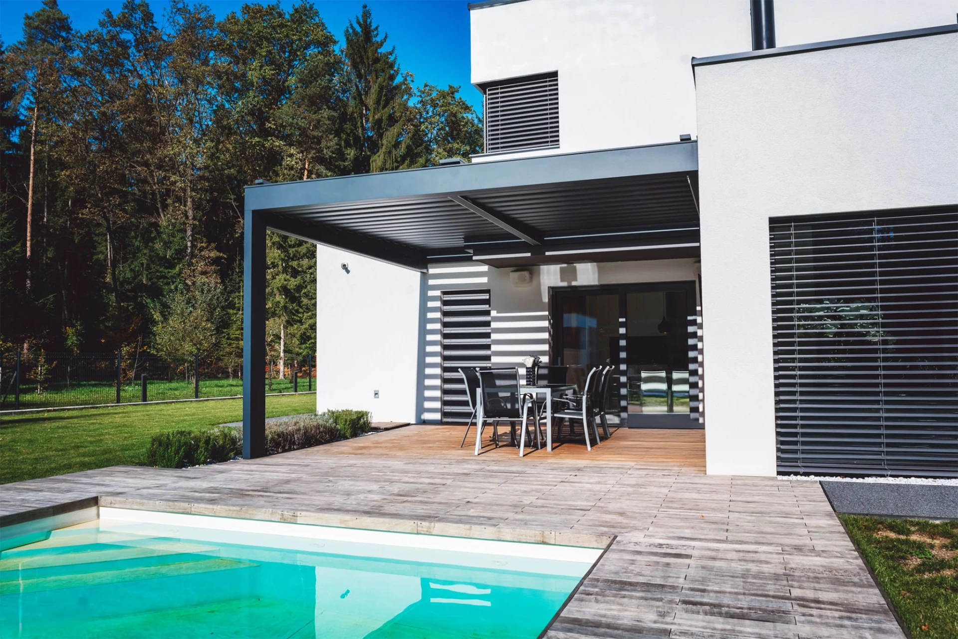 modern-house-with-patio-and-swimming-pool-with-sunroof-pergola-and-big-trees-beside-the-white-house-in-needham-ma