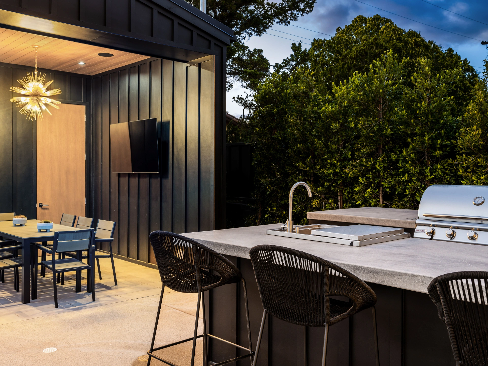 modern-outdoor-kitchen-and-dining-area-with-lighting-and-tv-in-needham-ma