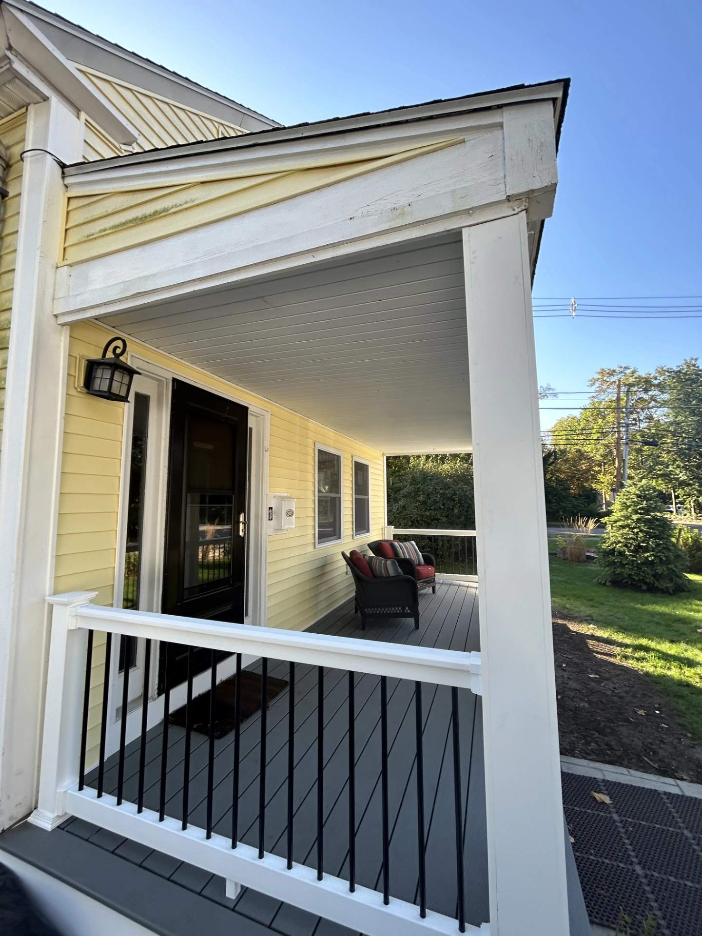 perspective-view-of-the-residential-deck-with-white-and-black-railing-and-a-couch-in-needham-ma