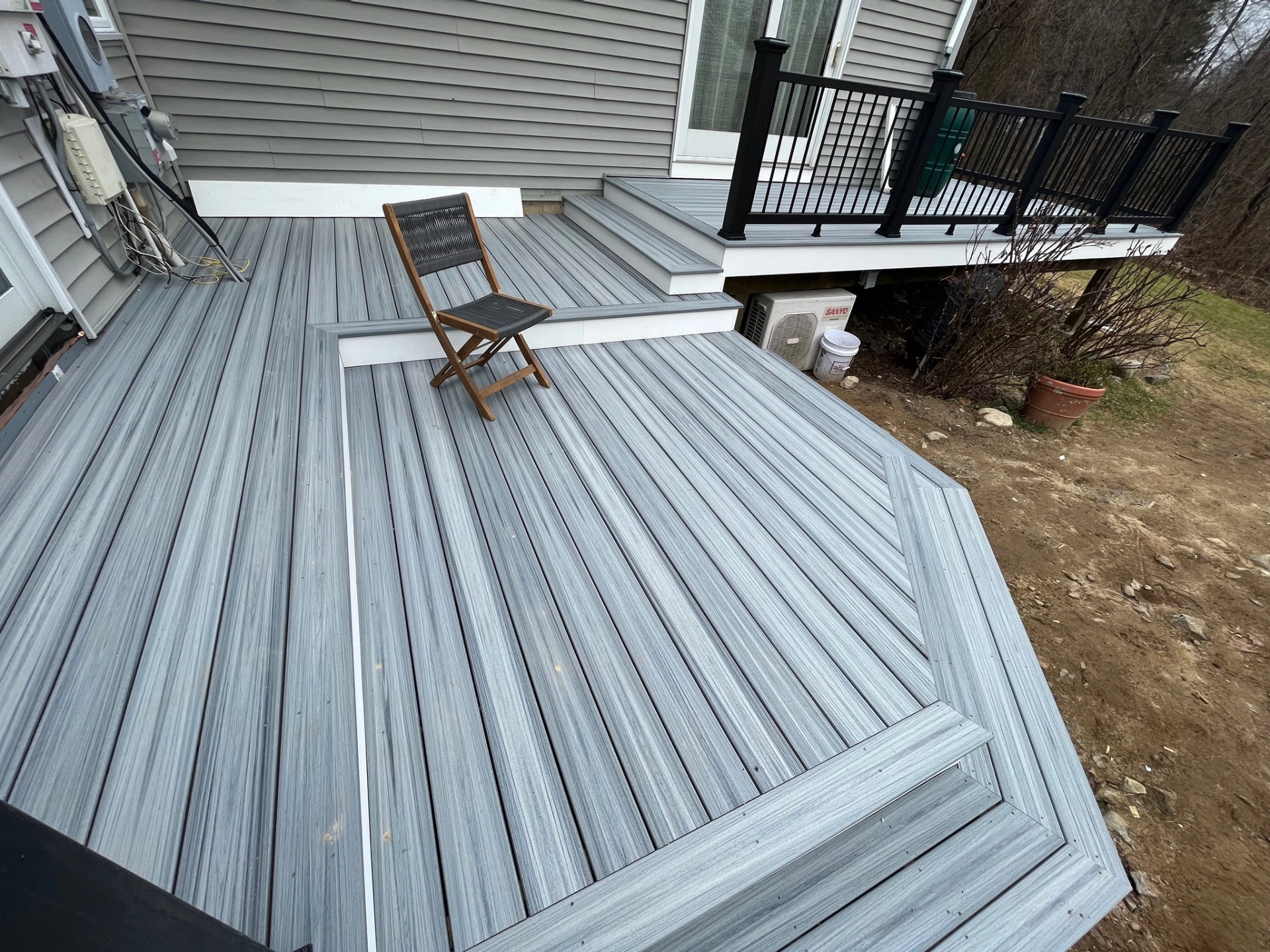 pvc-deck-installation-with-black-railing-and-a-chair-in-needham-ma